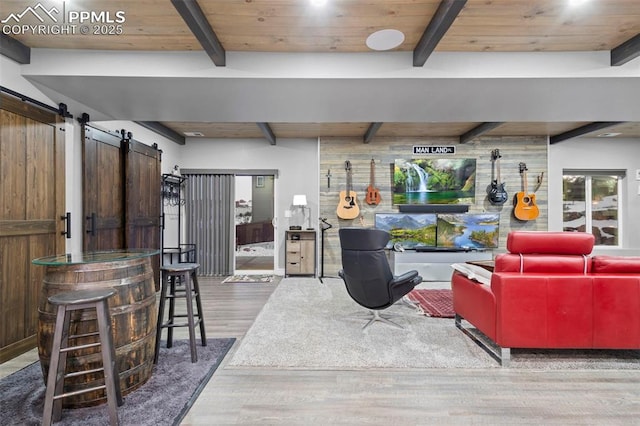 living room with beam ceiling, a barn door, wood-type flooring, and wood ceiling