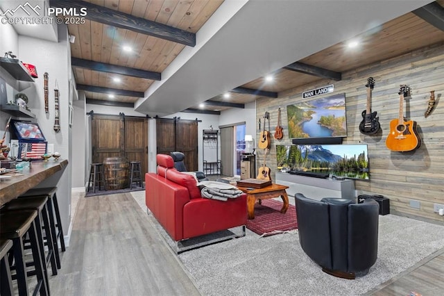 living room with a barn door, hardwood / wood-style floors, beamed ceiling, wooden walls, and wooden ceiling