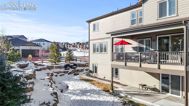 view of snowy exterior with a balcony and a patio