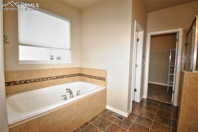 bathroom with tiled bath and tile patterned flooring