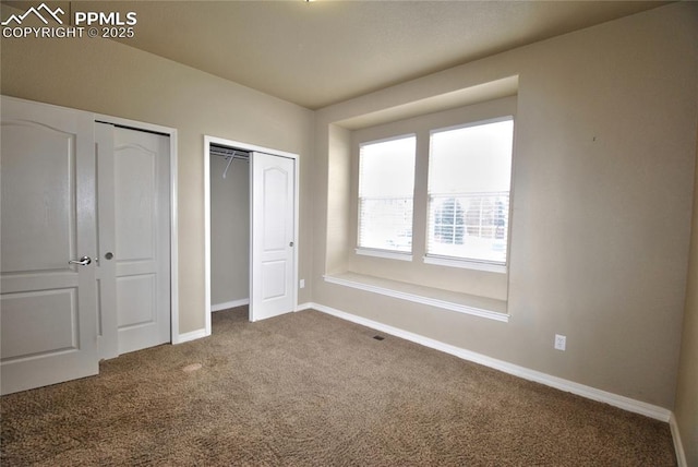 unfurnished bedroom with carpet flooring and two closets