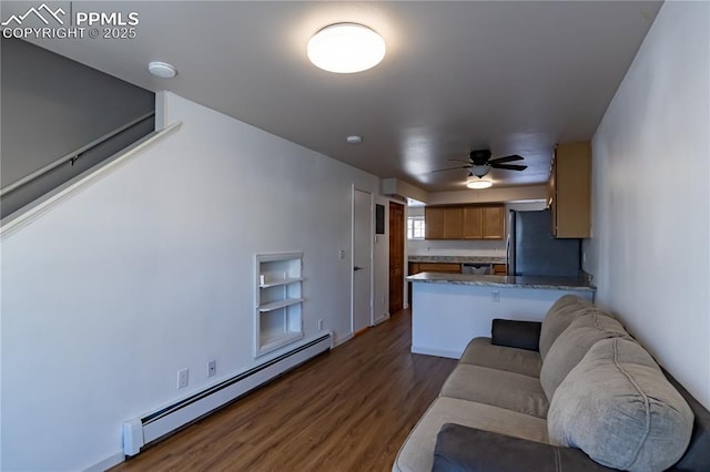 living room featuring baseboard heating, dark hardwood / wood-style floors, and ceiling fan