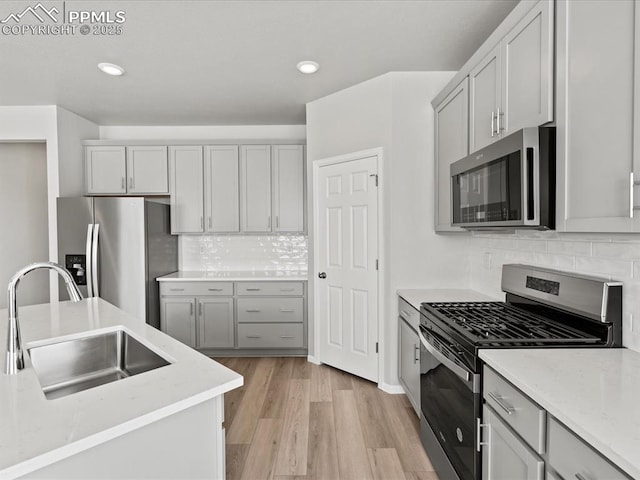 10434 Devoncove Dr, Peyton, CO 80831 - kitchen featuring gray cabinets, appliances with stainless steel finishes, light wood-style flooring, and a sink