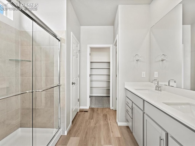 10434 Devoncove Dr, Peyton, CO 80831 - full bath with a sink, a walk in closet, wood finished floors, and a shower stall