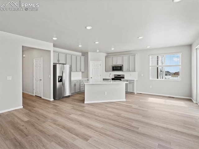 10434 Devoncove Dr, Peyton, CO 80831 - kitchen featuring light wood finished floors, open floor plan, light countertops, gray cabinets, and appliances with stainless steel finishes