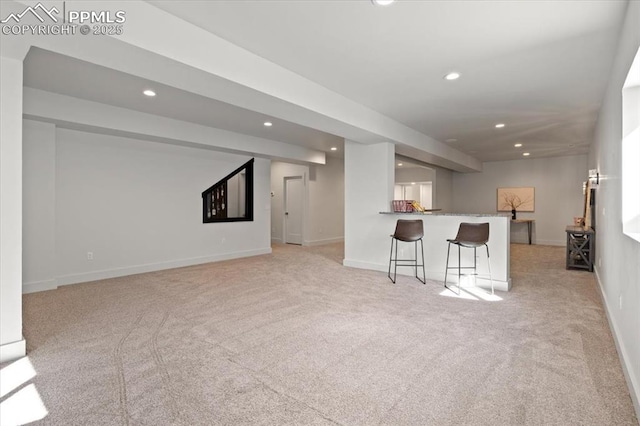 unfurnished living room with light colored carpet and bar area