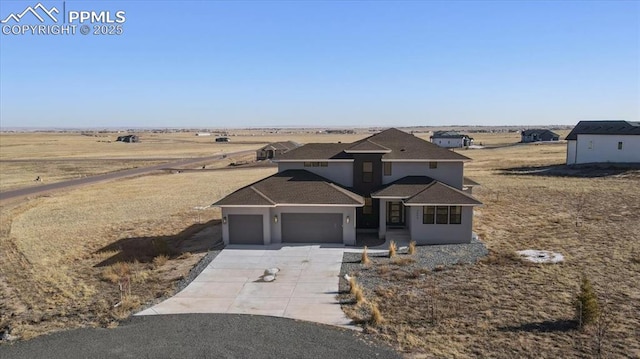 view of front facade with a garage and a rural view