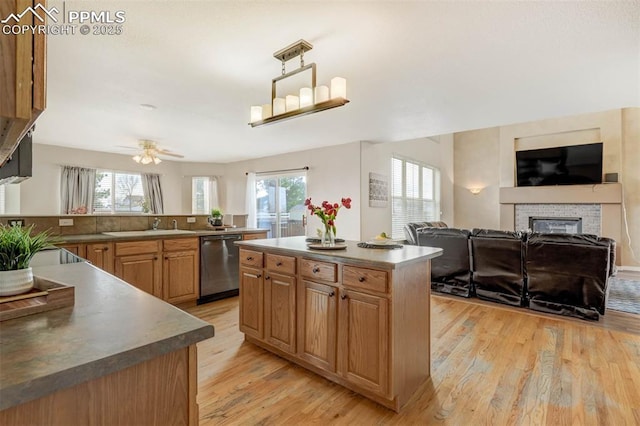 kitchen with ceiling fan, a center island, stainless steel dishwasher, and light wood-type flooring