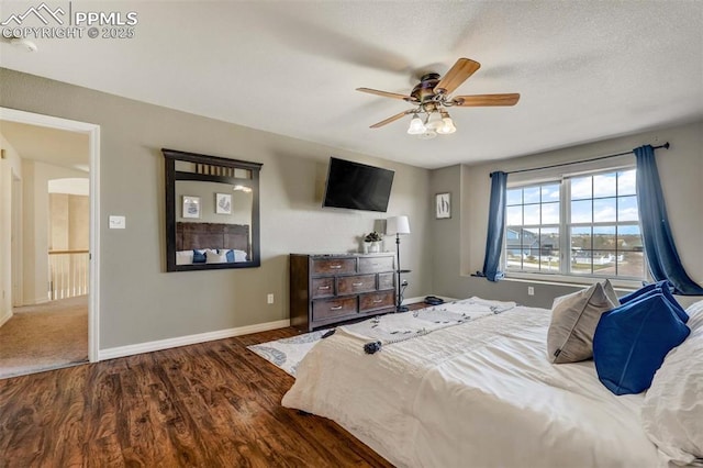 bedroom with ceiling fan, dark hardwood / wood-style flooring, and a textured ceiling