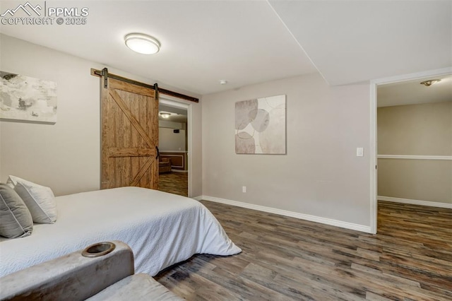 bedroom with dark hardwood / wood-style floors and a barn door