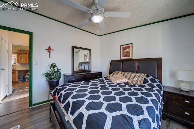 bedroom with ceiling fan, dark wood-type flooring, and a textured ceiling