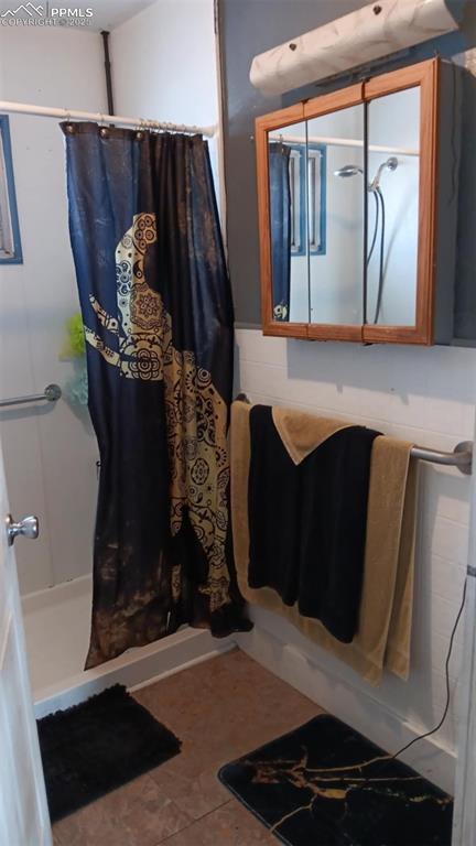 bathroom featuring a shower with curtain and tile patterned floors