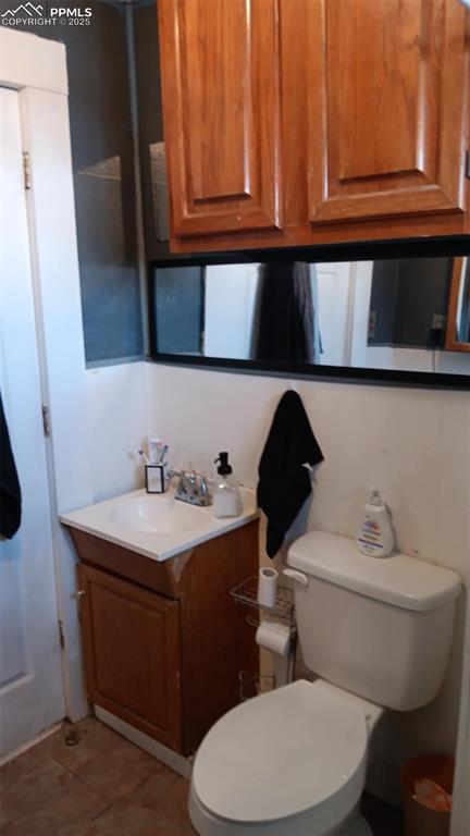 bathroom with tile patterned flooring, vanity, and toilet