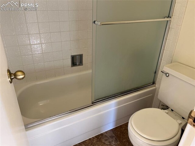 bathroom featuring bath / shower combo with glass door and toilet