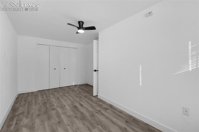 unfurnished bedroom with ceiling fan, light hardwood / wood-style flooring, and a closet