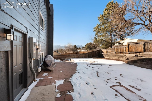 yard layered in snow with a patio area