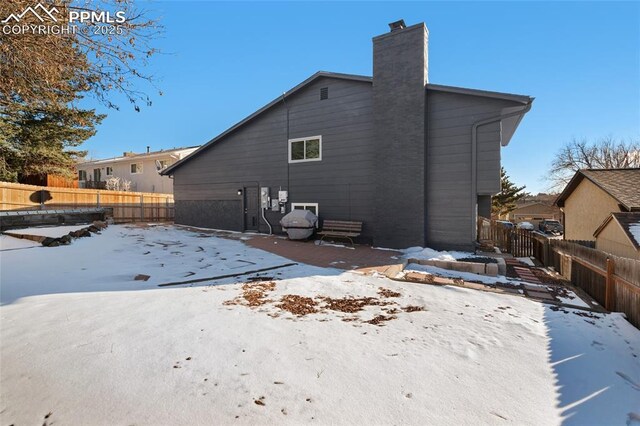 view of snow covered rear of property