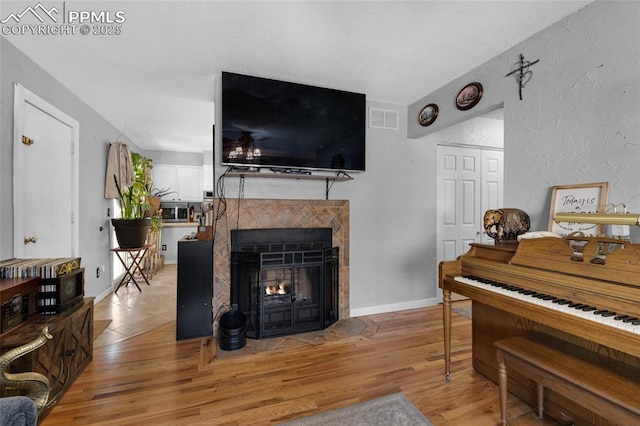 interior space featuring a tiled fireplace and light hardwood / wood-style flooring