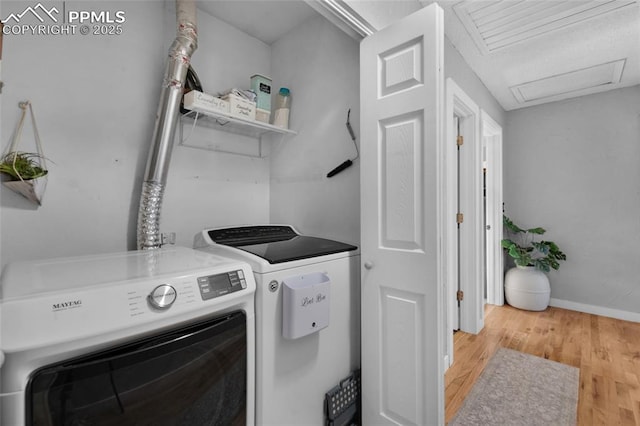 laundry room with separate washer and dryer and hardwood / wood-style flooring