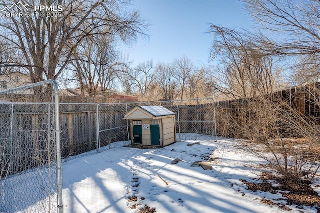 yard covered in snow with a storage unit