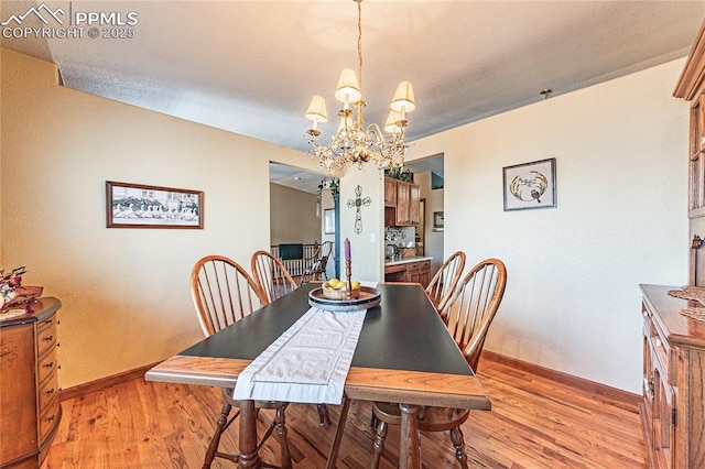 dining area with a chandelier and light hardwood / wood-style floors