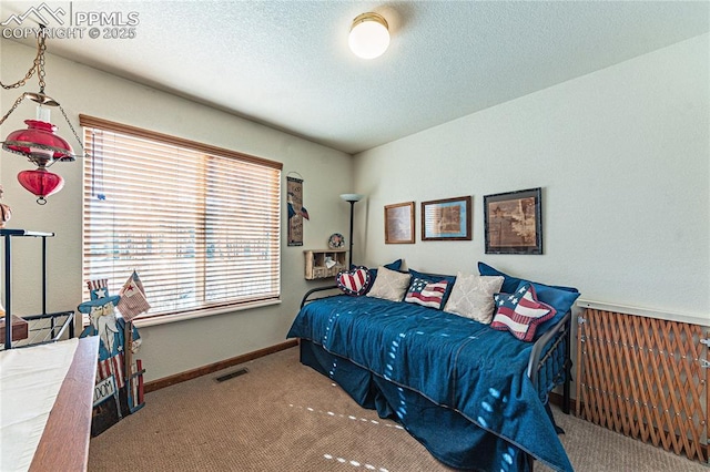 bedroom featuring a textured ceiling and carpet flooring