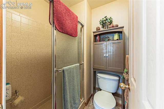 bathroom with toilet and a shower with door