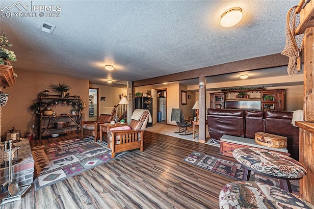 living room with a textured ceiling and wood-type flooring