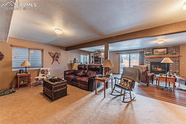 carpeted living room featuring a fireplace and a textured ceiling