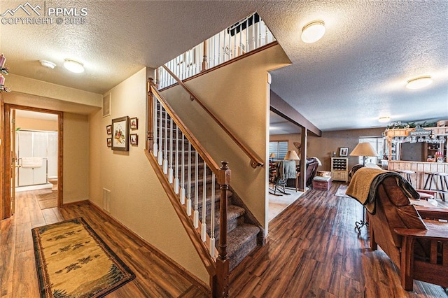 staircase featuring a textured ceiling and wood-type flooring