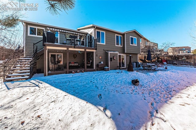 snow covered property with a balcony