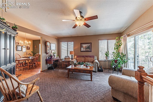 living room with ceiling fan with notable chandelier, a textured ceiling, and carpet floors