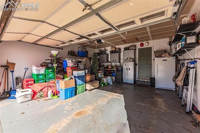 garage featuring white refrigerator and a garage door opener