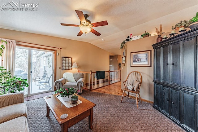 carpeted living room with ceiling fan and vaulted ceiling