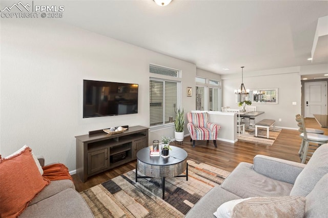 living room with dark hardwood / wood-style flooring and a notable chandelier