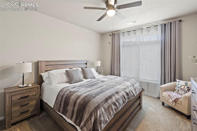 bedroom featuring light carpet, a textured ceiling, and ceiling fan