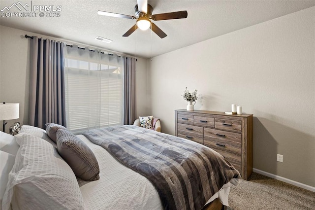 carpeted bedroom with ceiling fan and a textured ceiling