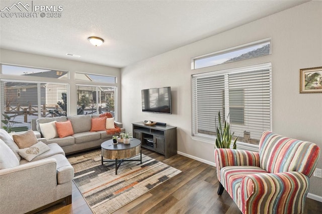 living room with dark wood-type flooring and a textured ceiling