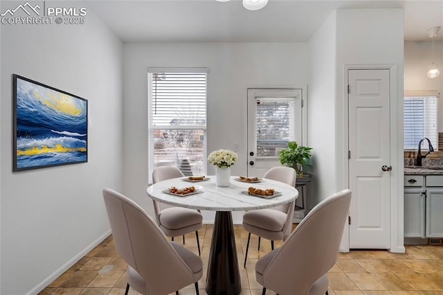 dining space featuring sink and light tile patterned floors