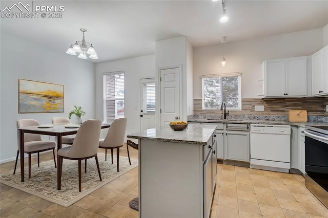 kitchen with white cabinetry, dishwasher, decorative backsplash, hanging light fixtures, and a kitchen island