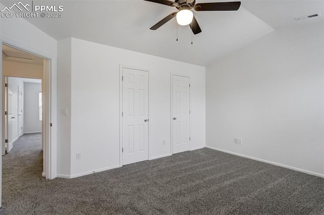 unfurnished bedroom with lofted ceiling, ceiling fan, and dark colored carpet