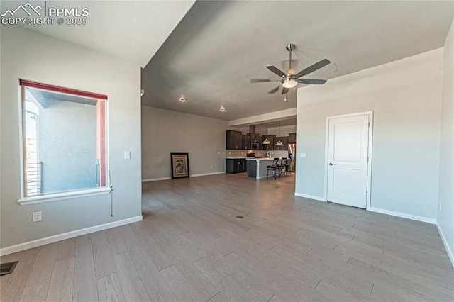 unfurnished living room featuring light wood-type flooring and ceiling fan