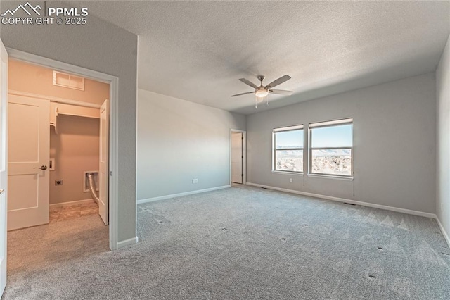 unfurnished room with ceiling fan, light colored carpet, and a textured ceiling