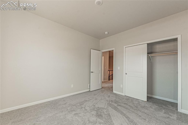 unfurnished bedroom with a closet and light colored carpet