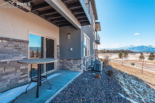 view of patio with a mountain view and central air condition unit