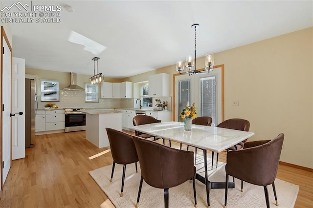 dining space with a notable chandelier and light hardwood / wood-style flooring