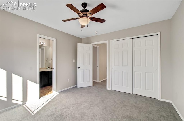 unfurnished bedroom with ensuite bath, a closet, ceiling fan, and light colored carpet