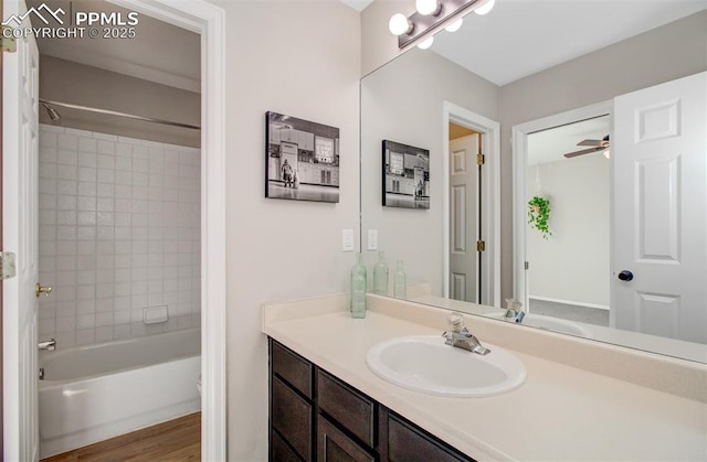 bathroom featuring hardwood / wood-style floors, vanity, and tiled shower / bath