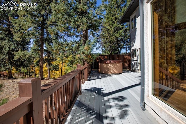 wooden deck with a hot tub