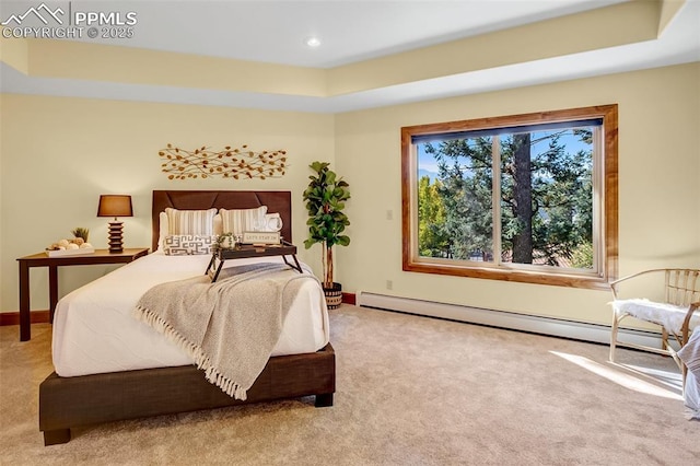 carpeted bedroom with a raised ceiling and a baseboard heating unit